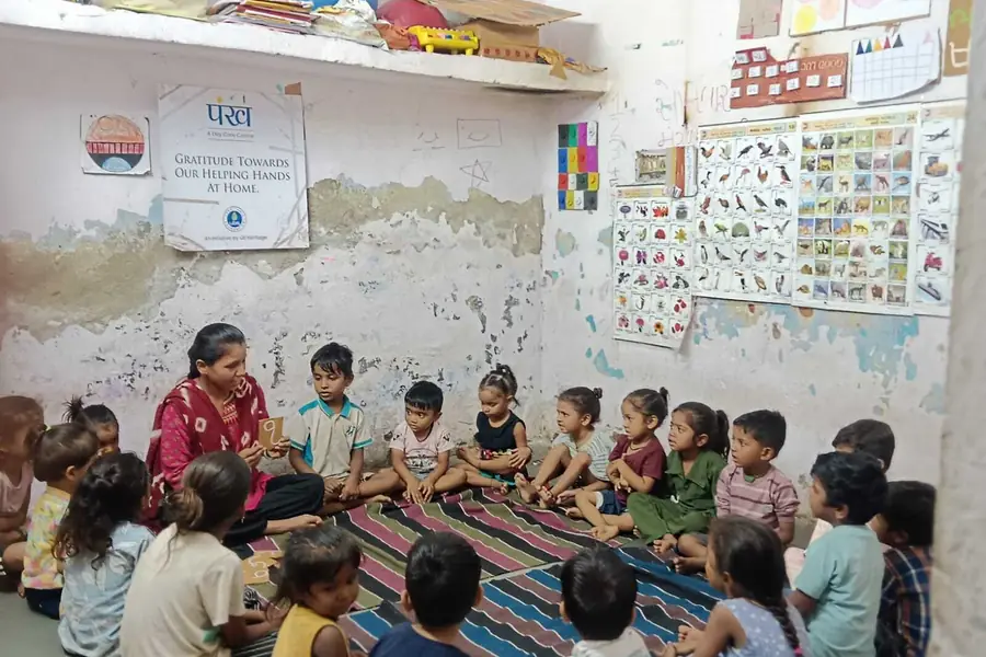 A पंख centre in session, children on mats beneath the charts on the wall