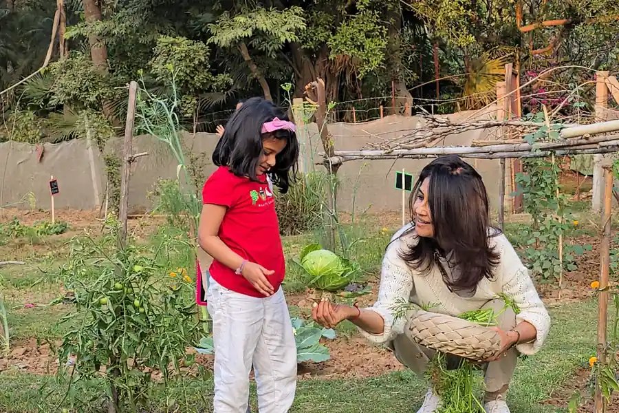 Two girls carrying the gourds they have picked