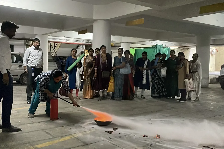 A participant putting out the fire with an extinguisher as the group watches