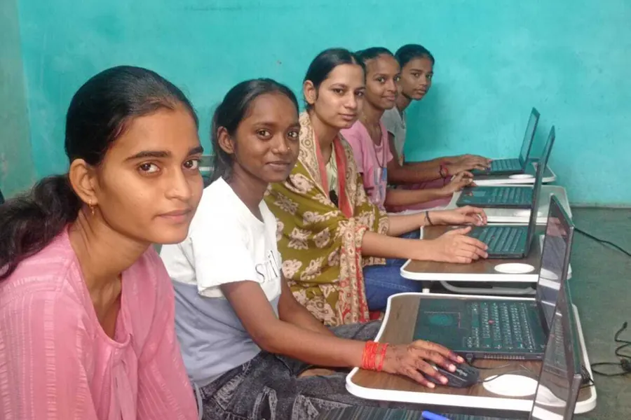Students at laptops along the length of the computer room