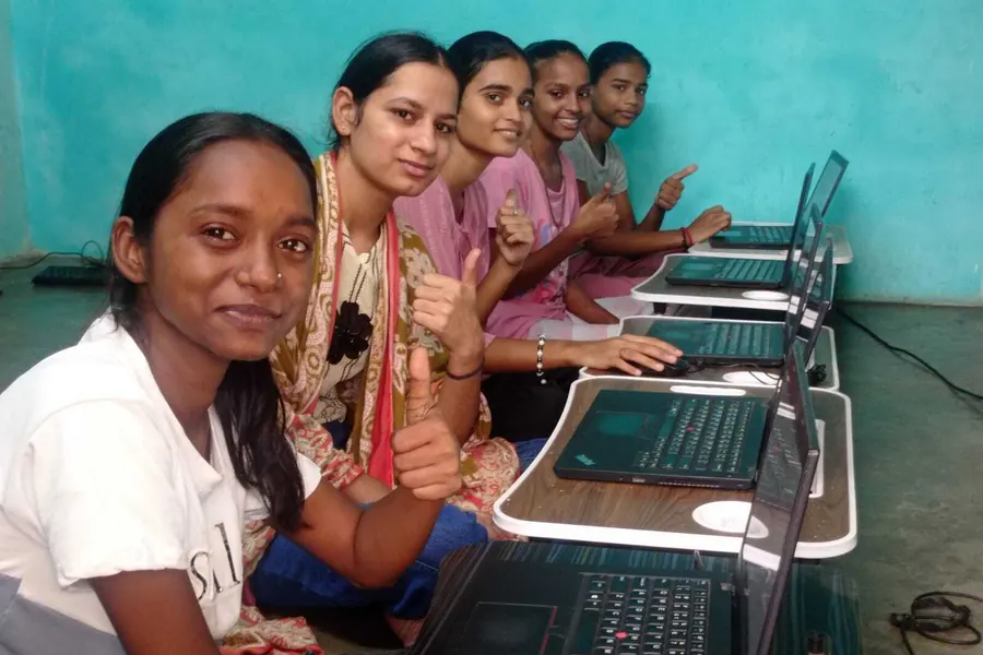 Students side by side at the laptop bench