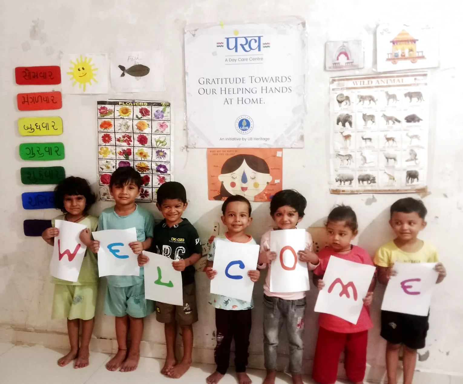 Children at a पंख centre holding up letters spelling WELCOME