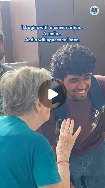 A young volunteer sitting with an elderly resident