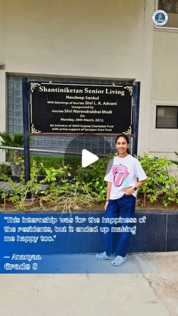 An intern beside the Shantiniketan Senior Living foundation plaque